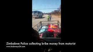 Cop takes bribe from motorist at a Roadblock in Zimbabwe