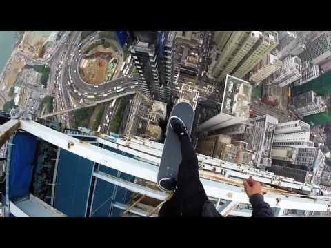Man Balances on Skateboard on Top of Skyscraper