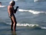 Anziano si riscalda in riva al mare..