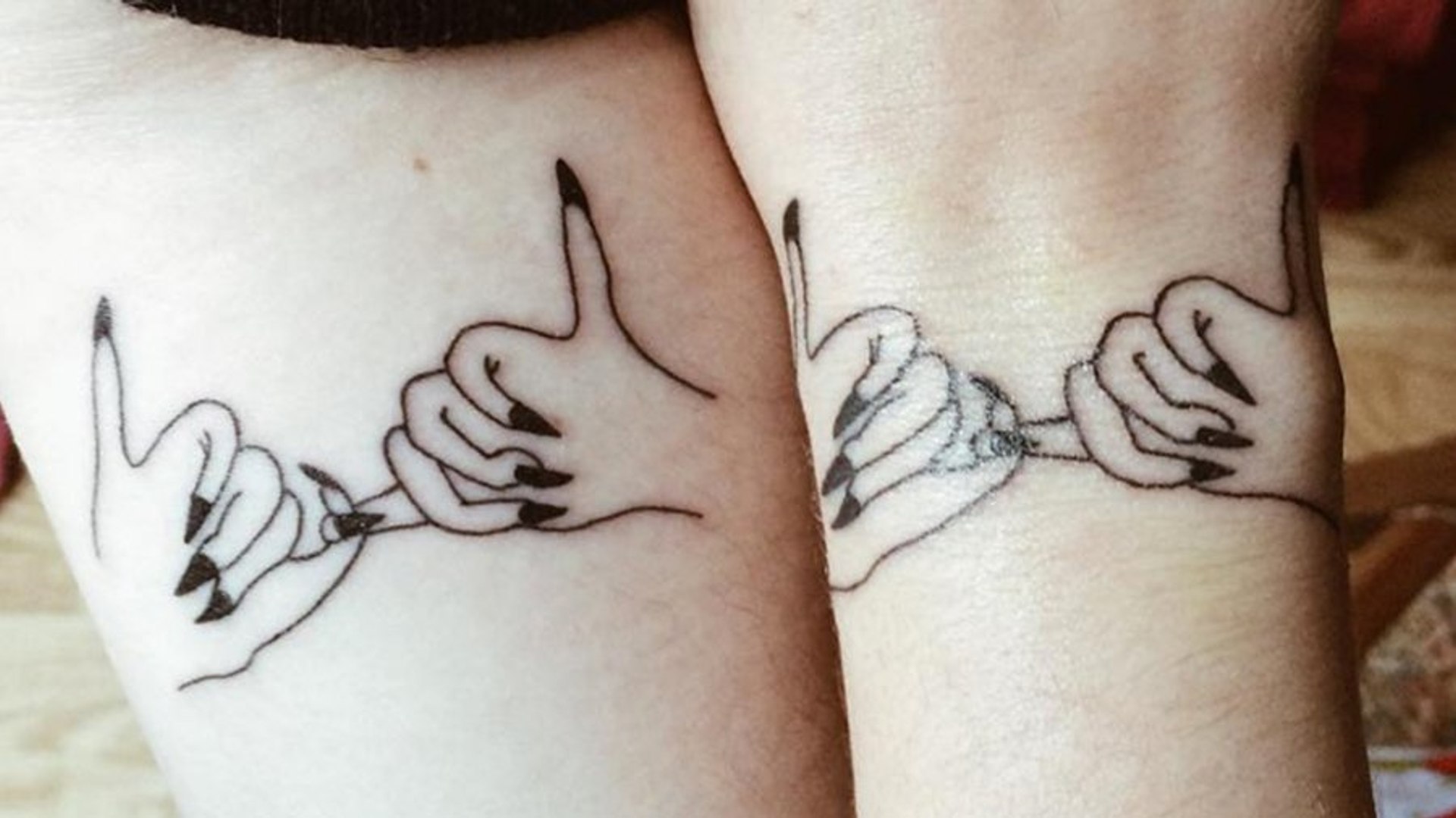 two hands holding each other tattoo