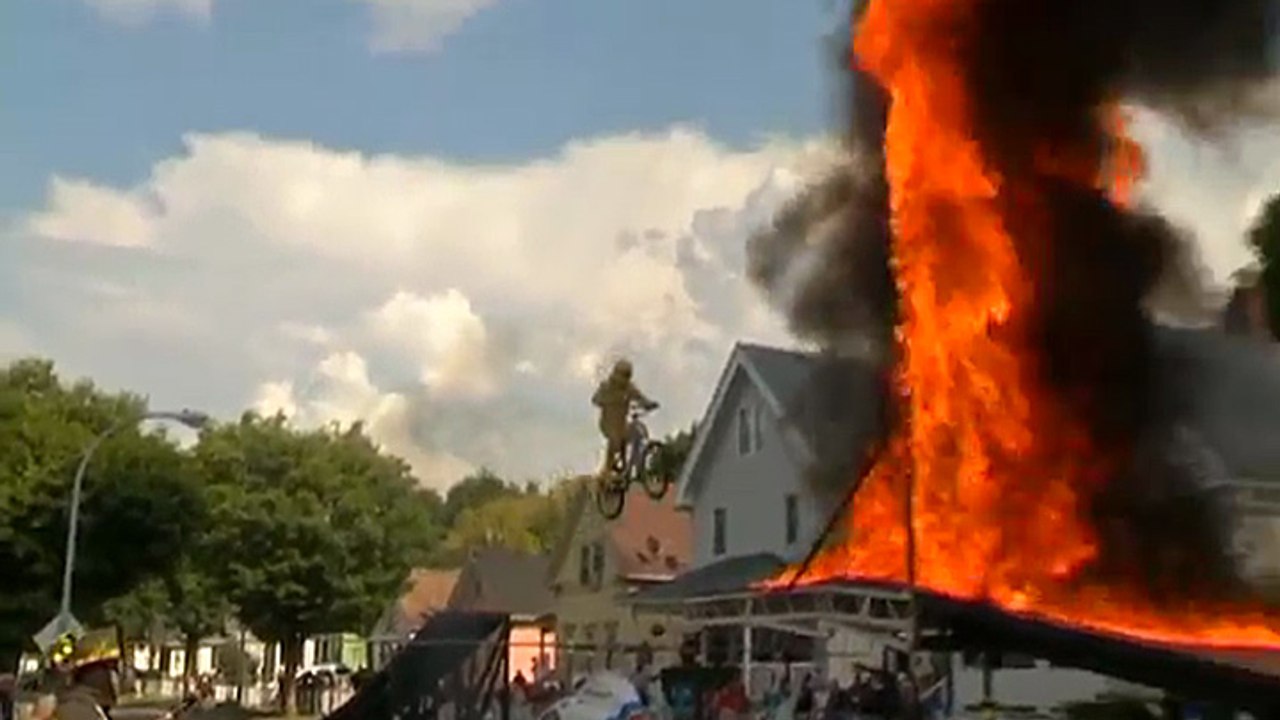Un pasteur traverse un mur de feu à vélo
