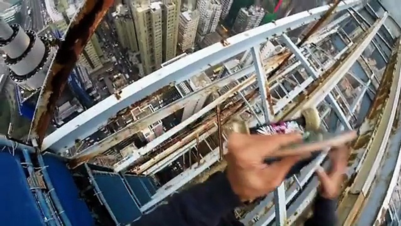 A skateboarder - Cheung Jai balance on the edge of a skyscraper in Hong Kong
