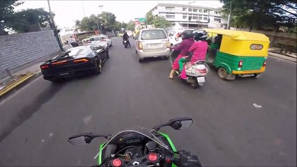Une lamborghini huracan et une kawasaki ninja font une course folle au milieu de la circulation.