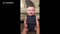 Baby can't stop laughing at mother tearing paper