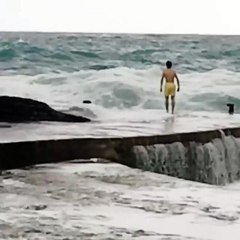 Il se jette du quai dans la mer déchainée