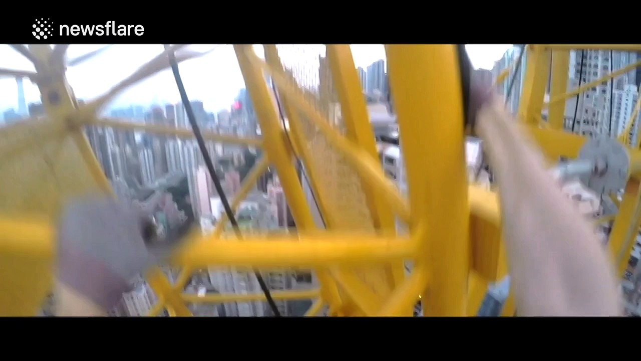 Man free climbs crane mounted on top of a skyscraper in Hong Kong