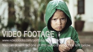 Poor lonely child staying alone in the rain and catching raindrops by hand. Video stock footage