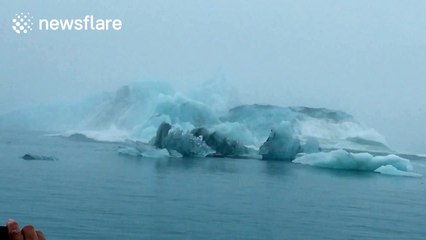 Iceberg flips over in front of tourist boat in Iceland