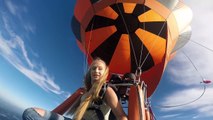 Une nana au déc0lleté généreux se fait un petit saut en parachute d'une montgolfière