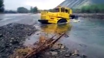 A Russian tractor driver refuses to give up after his vehicle gets stuck in a river