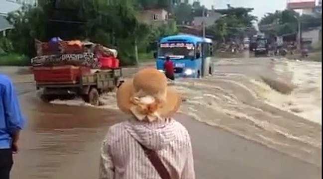 Hành khách phụ tài xế đẩy xe vượt lũ