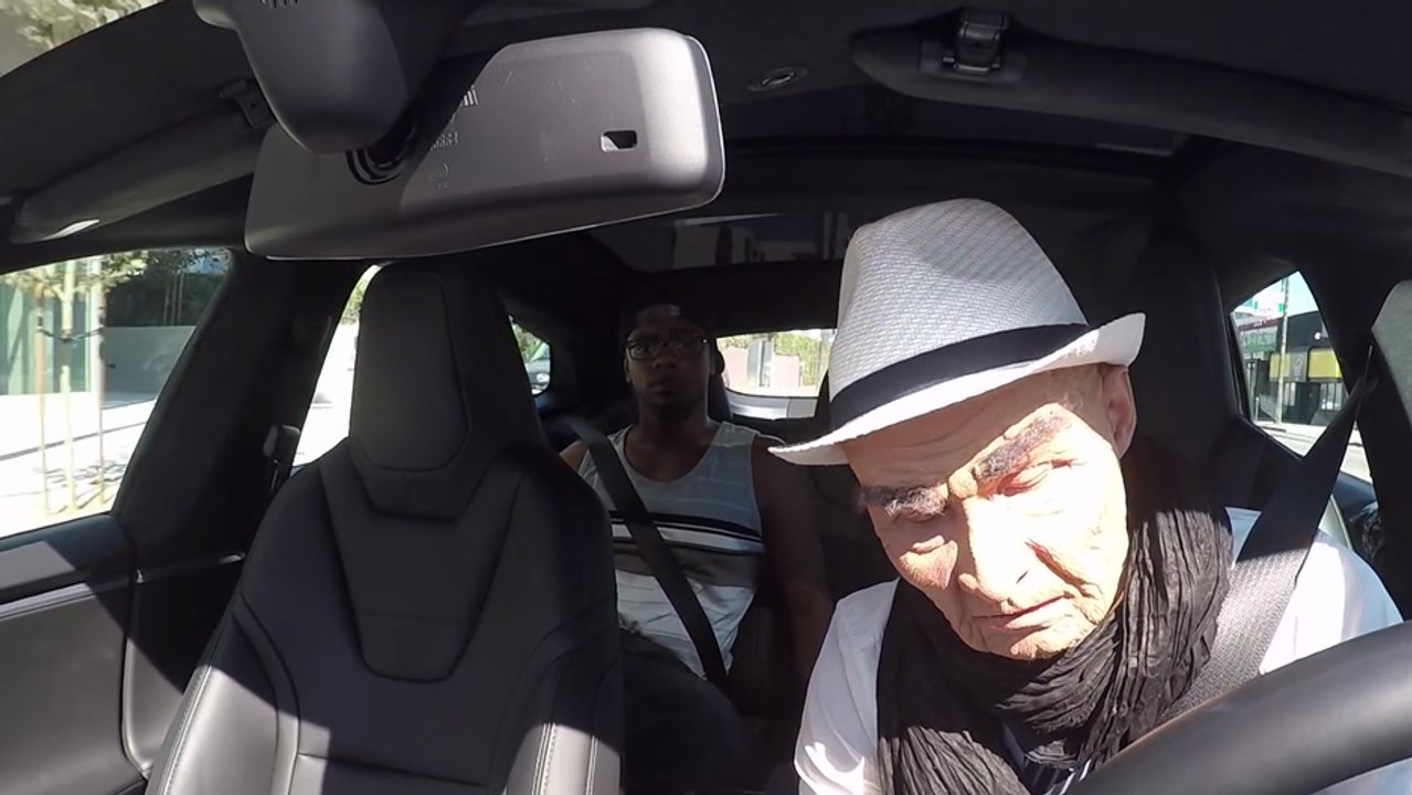 Josh PalerLin déguisé en vieux fait semblant de s'endormir au volant d'une tesla avec l'autopilot activé
