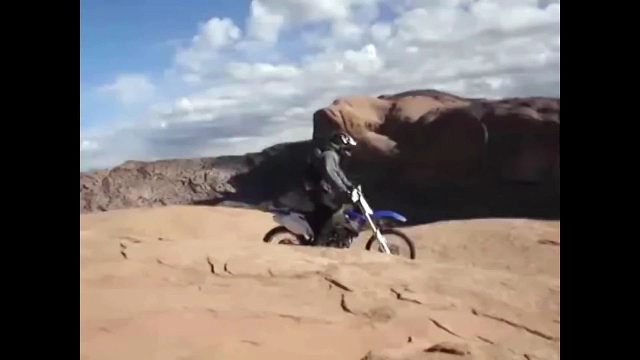 Un motard fou roule sur la paroi d'une falaise au péril de sa vie