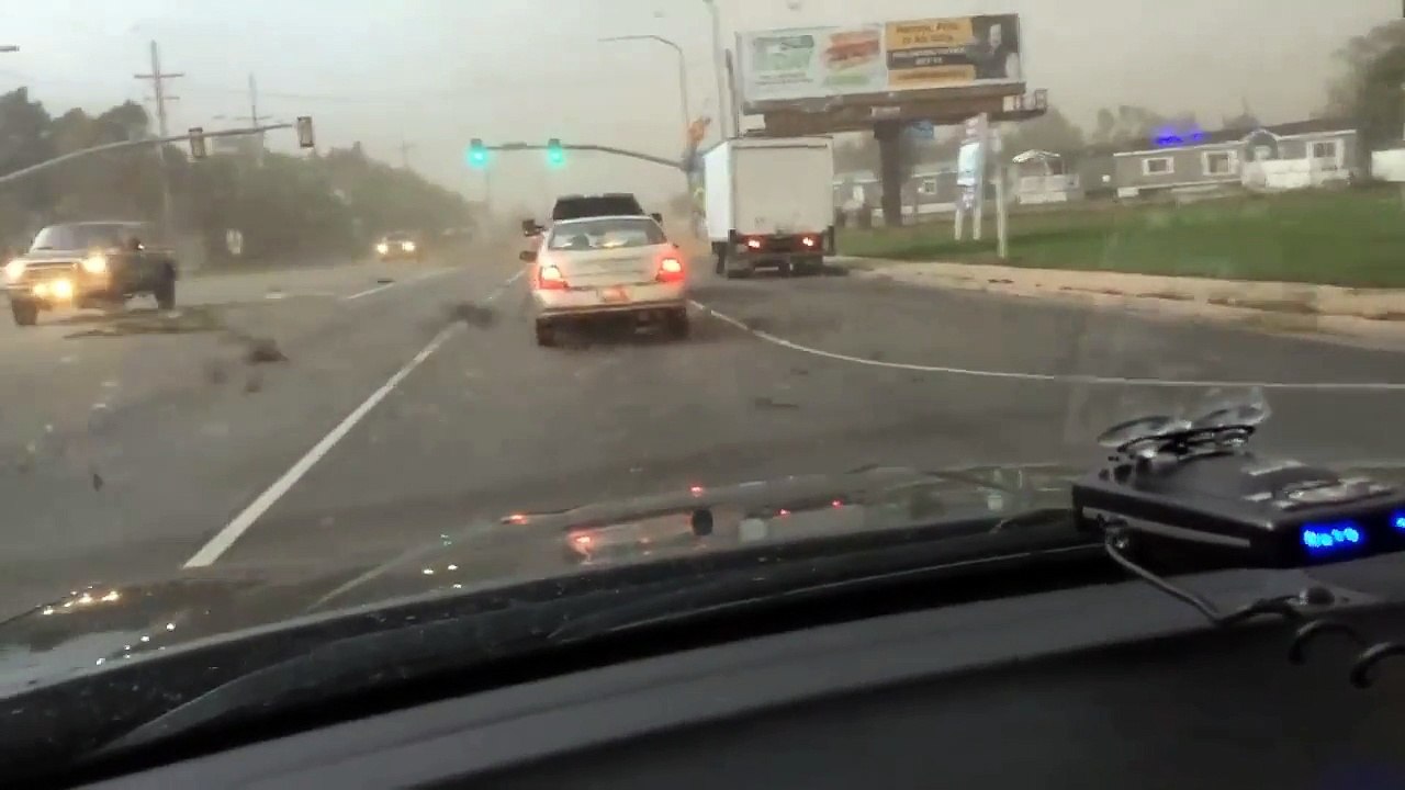 Un automobiliste pris dans une tornade à un feu rouge! Impressionnant