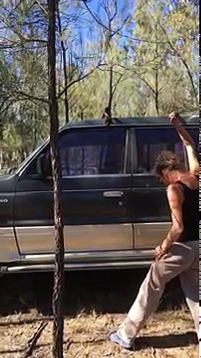 Une femme essaie de casser la vitre d'un SUV