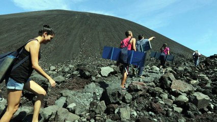 Au Nicaragua, des touristes descendent un volcan en sand-board
