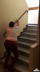 Un mec saute dans des escaliers en s'accrochant à la rampe
