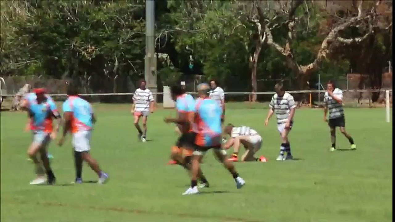 Un rugbyman fait un salto arrière pour éviter un plaquage