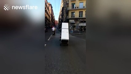 Two men filmed trying to transport a fridge on a motorbike