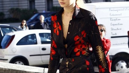 Gigi Hadid flashes a glimpse of her lacy black bra in steps out during Paris Fashion