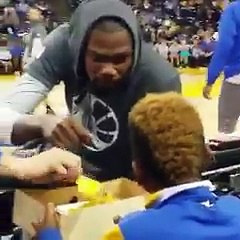 Kevin Durant pique un nacho à un enfant sur le bord du terrain