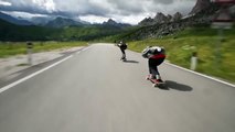 Downhill skateboarders flying by cyclists at 70 mph