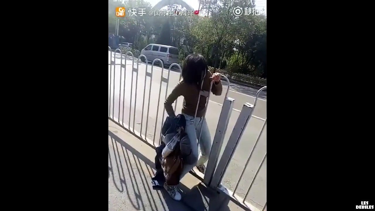 Une nana se retrouve coincée entre des barrières