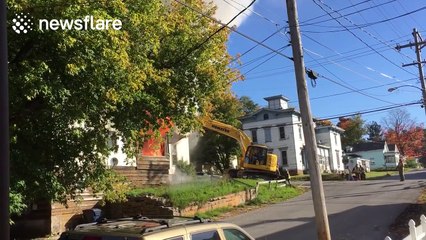 Construction workers use excavator to rescue man from burning building