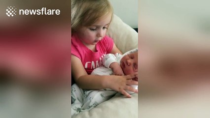 Toddler sings song to her newborn sister