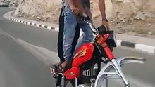 Deux jeunes roulent en moto sans la roue avant