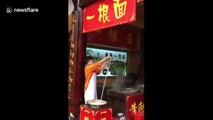 Enthusiastic man pulls single-strand noodle while dancing