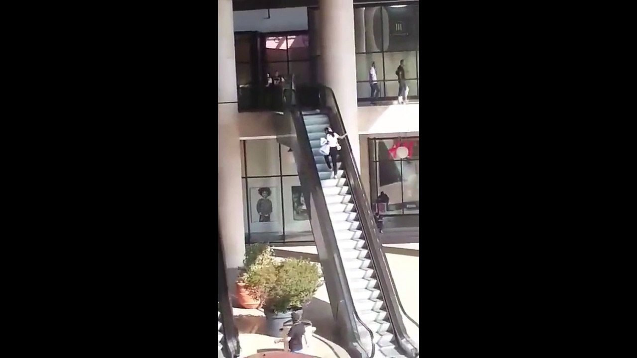 Cette débile monte un escalator à l'envers.... Elle est pas arrivée