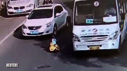 Un enfant en trotteur au milieu des voitures