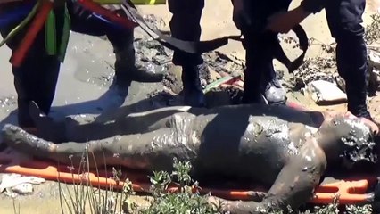 Un homme ivre repêché dans une rivière, couvert de boue