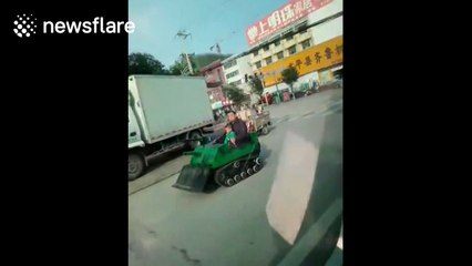Man and grandson drive toy tank on road