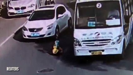 Un enfant en trotteur au milieu des voitures