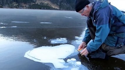 He puts the knife into the ice and lights a match.