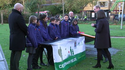 William helps children plant poppies for Britain's war dead