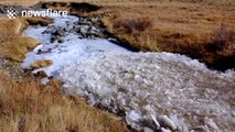 Crumbling ice flows along creek in Russia