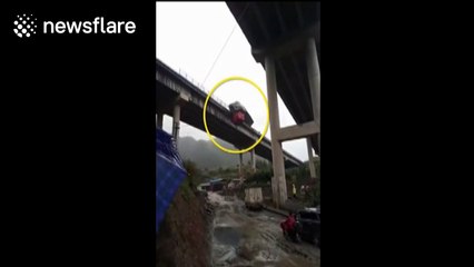 Out-of-control trailer hangs off the edge of a bridge