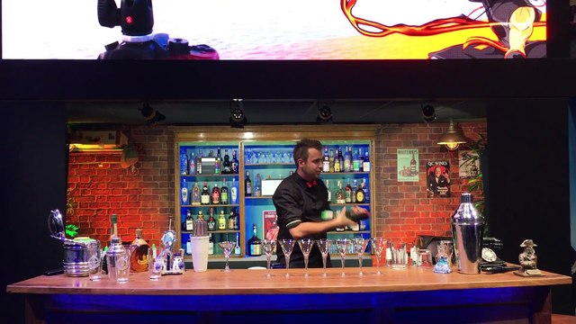 Un barman fait tourner une bouteille