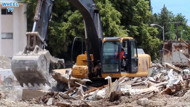 DEERE 270D Excavator moving around debris from a torn down building on a construction site