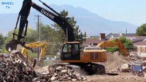 Deere 270D Excavator moving debris and driving on a constrution site of a torn down building