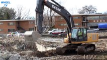 Deere 270 Excavator demolishing a foundation from a torn down building