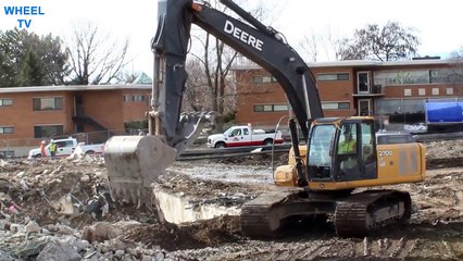 Deere 270 Excavator demolishing a foundation from a torn down building