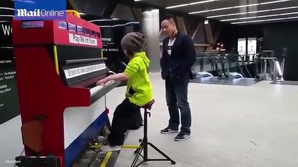 A little girl plays the piano on the subway.