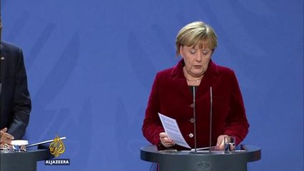 Obama visits Merkel in Germany, prods Trump on Russia