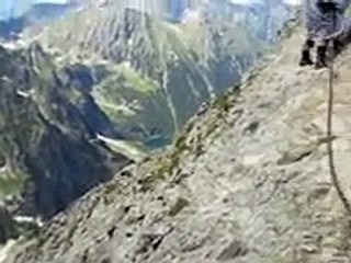 Une nonne sur une via ferrata au dessus d'une crete