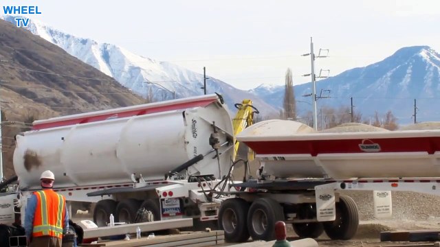Double Big Rig Dump Truck dumping its load on a rock pile at a construction site