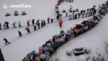 Aerial footage of hundreds of students walking home in the snow
